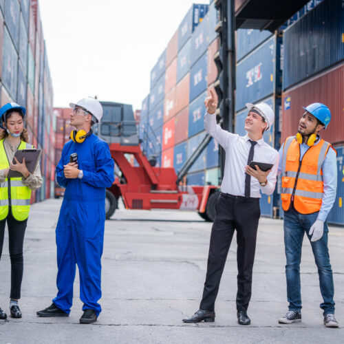 Engineer team and Businessman planning the transportation of goods for import or export in the container yard.