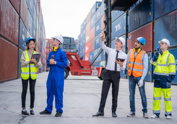 Engineer team and Businessman planning the transportation of goods for import or export in the container yard.